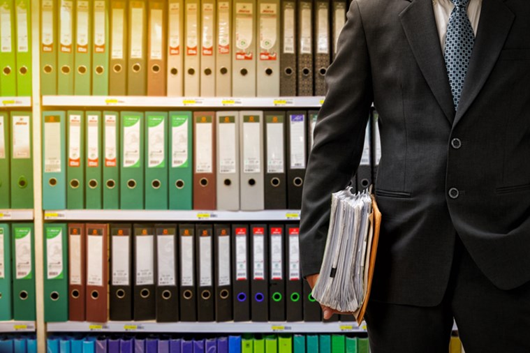 Broker in front of an organized filing system.