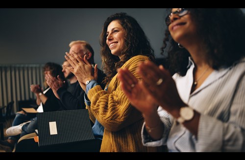 Crowd of people clapping at a Broker conference