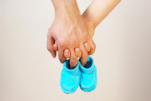 hands holding baby shoes